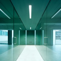 Umnutzung eines Fabrikgebäudes zu Büros. Fast alle Wände sind dieses Bürogebäudes sind aus 12 mm starkem grün schimmerndem Sicherheitsglas gebaut